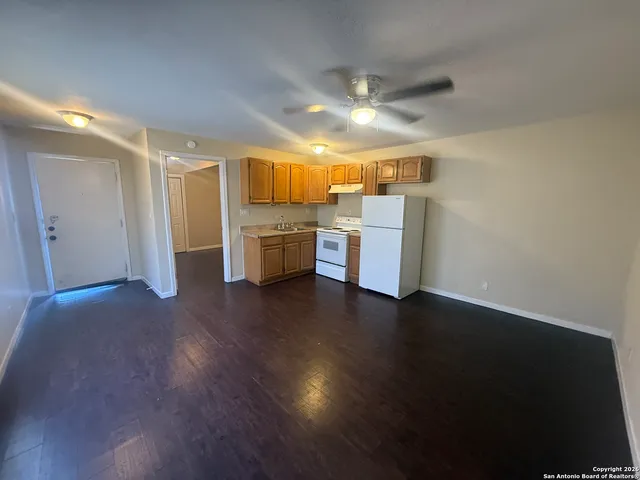 a view of a kitchen with a sink and dishwasher a oven with wooden floor