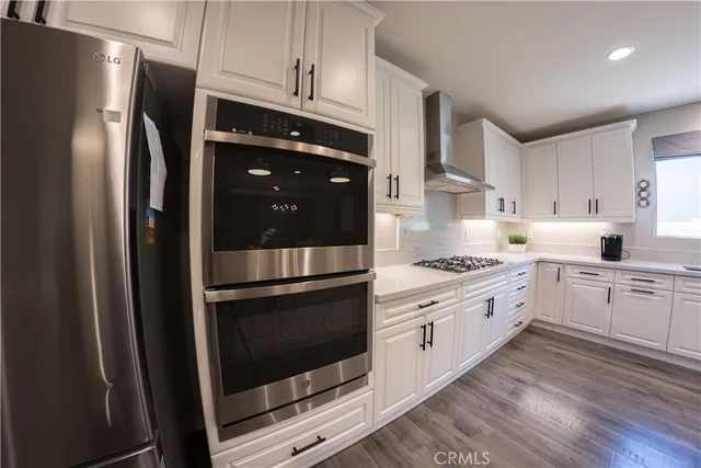 a kitchen with stainless steel appliances a stove a refrigerator and cabinets
