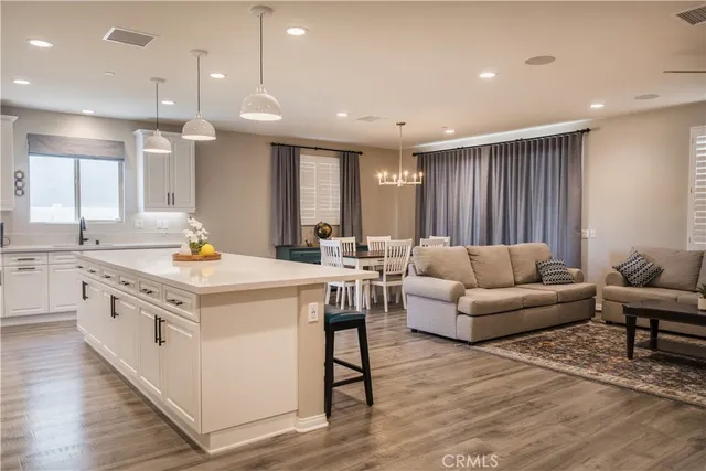 a view of kitchen island a sink wooden floor and living room