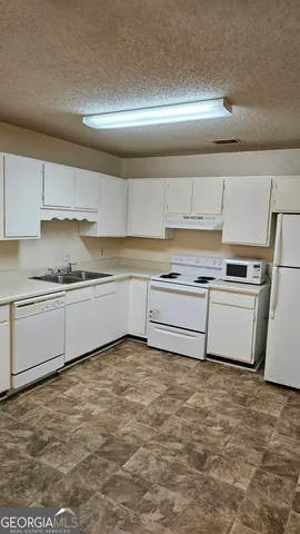 a kitchen with granite countertop a sink and cabinets