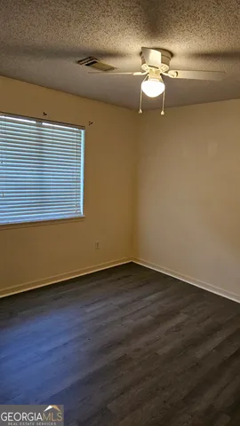 a view of empty room with wooden floor