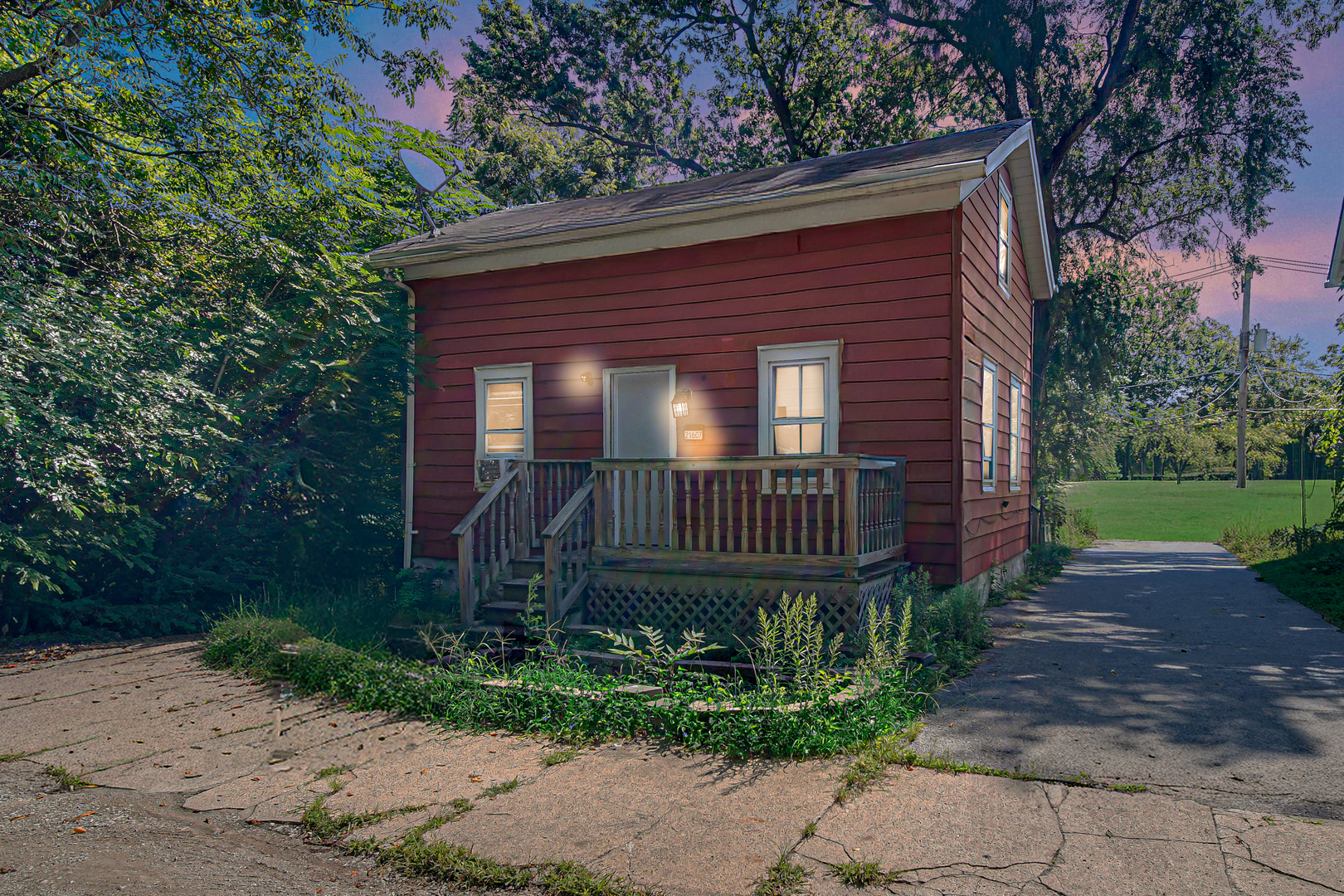 a view of a house with a small yard plants and large tree