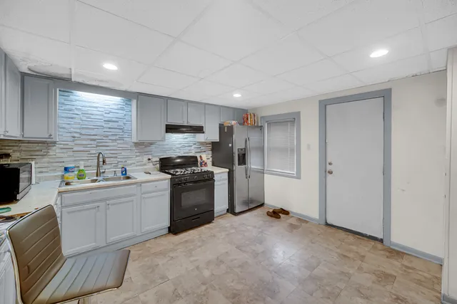 a kitchen with stainless steel appliances granite countertop a refrigerator sink and stove