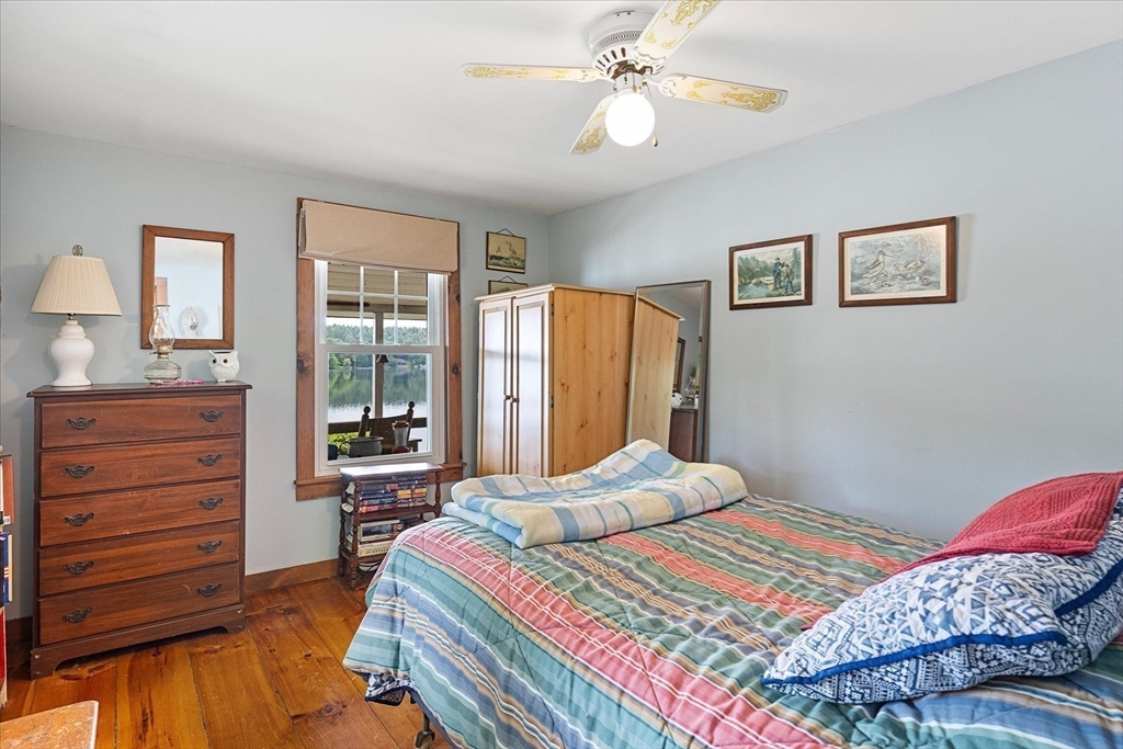 35 Mt Dan Road Sturbridge, MA 01518 - Photo 21 of 37 a bedroom with a bed a dresser and a chandelier