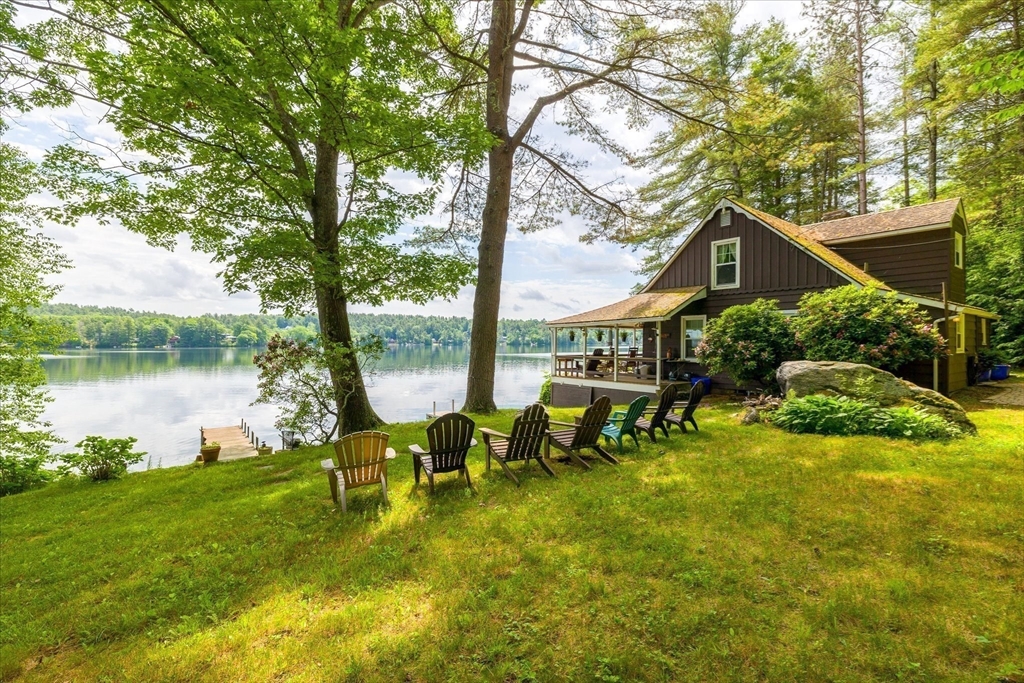 35 Mt Dan Road Sturbridge, MA 01518 - Photo 32 of 37 a backyard of a house with table and chairs floor to ceiling window and a tree