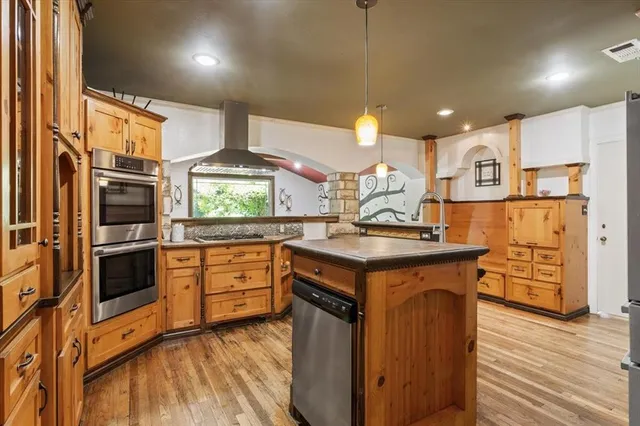 a kitchen with stainless steel appliances granite countertop a sink a stove and a refrigerator