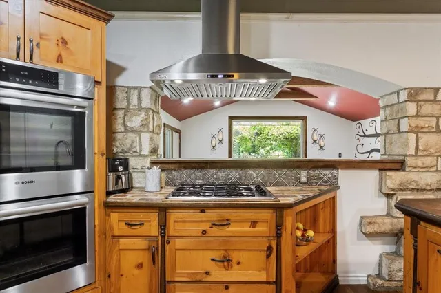 a kitchen with stainless steel appliances granite countertop a stove a sink and a microwave