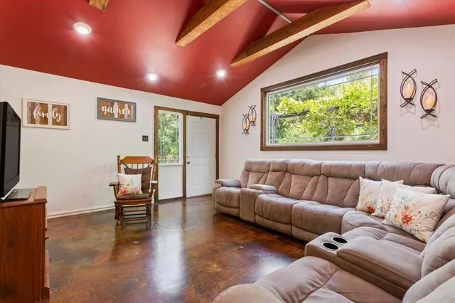 a living room with furniture a large window and a flat screen tv