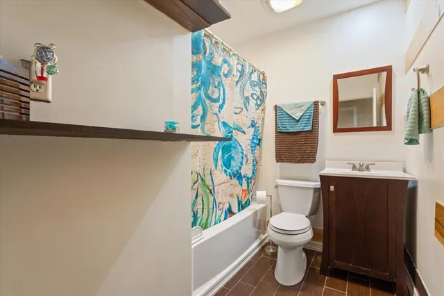 a bathroom with a toilet and a shower curtain