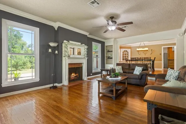 a living room with furniture a fireplace and a large window