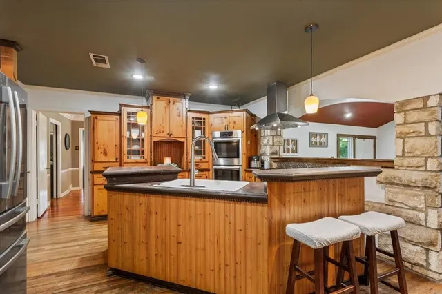 a kitchen with stainless steel appliances granite countertop table chairs sink and cabinets