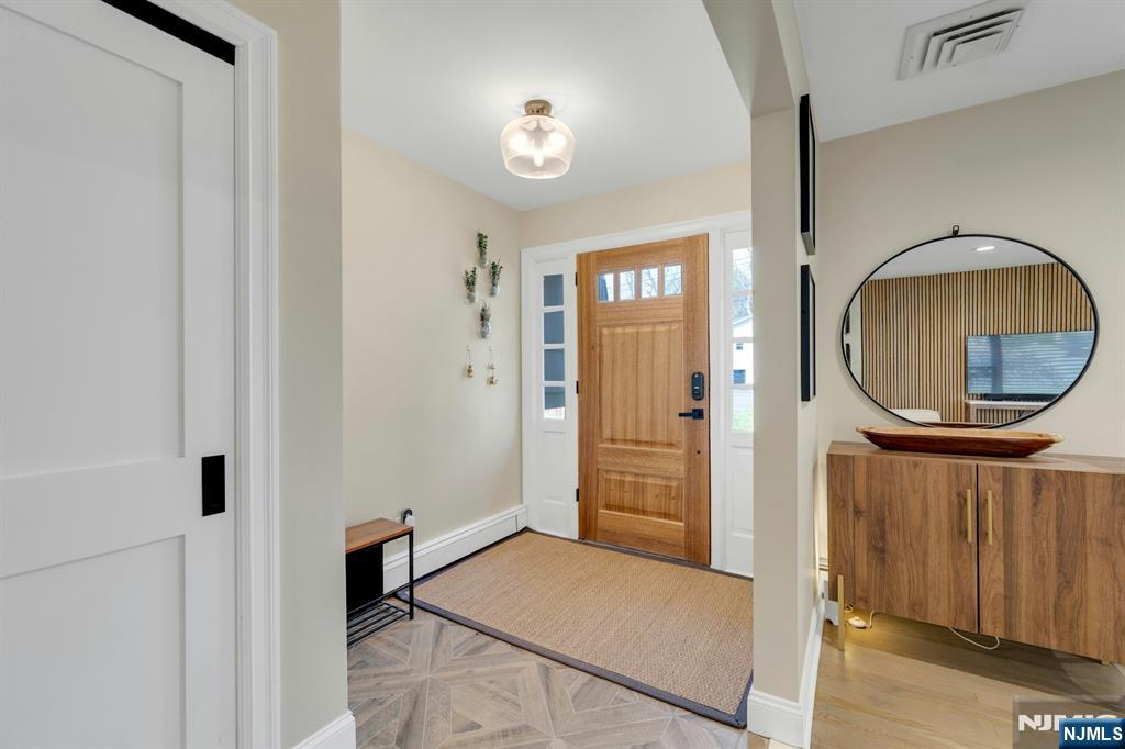 108 Hendrickson Street Haworth, NJ 07641 - Photo 13 of 38 a view of an entryway with wooden floor and mirror