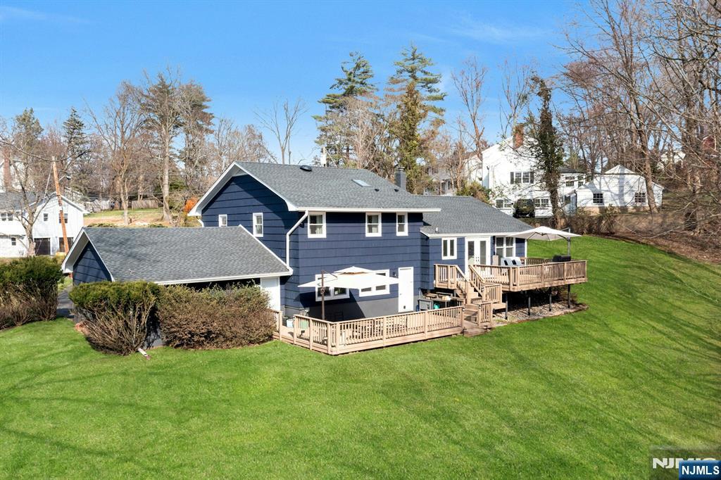 108 Hendrickson Street Haworth, NJ 07641 - Photo 32 of 38 a front view of a house with a garden and trees