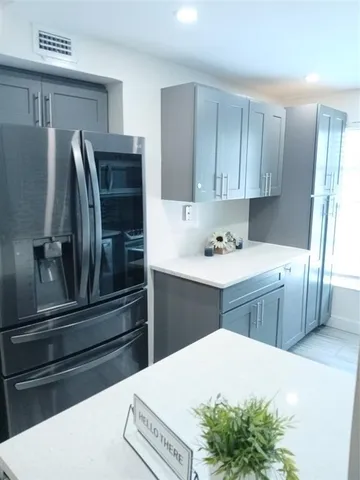 a kitchen with stainless steel appliances kitchen island granite countertop a refrigerator sink and stove