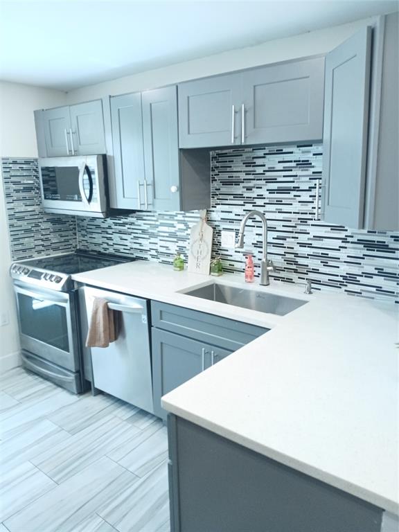 4170 Inverrary Drive, Unit 412 Lauderhill, FL 33319 - Photo 3 of 15 a kitchen with kitchen island granite countertop wooden cabinets and white appliances