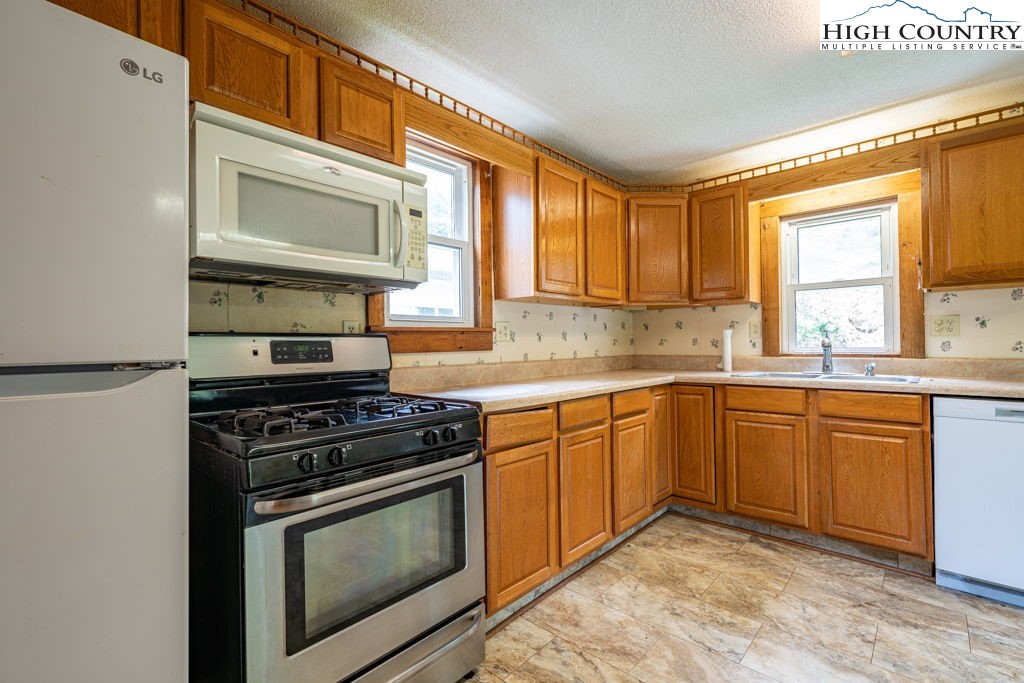 175 Roaring Fork Road Todd, NC 28684 - Photo 8 of 24 a kitchen with stainless steel appliances granite countertop a stove a sink and a microwave