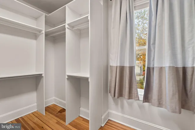a view of empty room with wooden floor