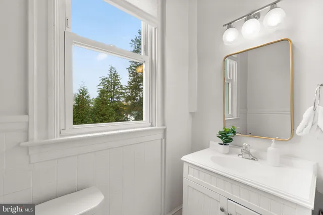 a front view of a house with a garden and a tree