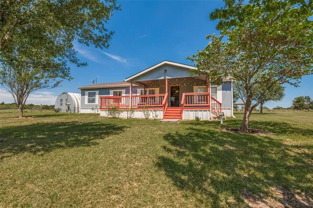 a view of a house with a yard balcony and sitting area
