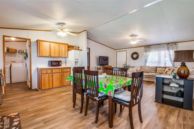 a kitchen with stainless steel appliances kitchen island granite countertop a table chairs and a refrigerator