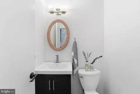 a view of a hallway with bathroom and wooden floor
