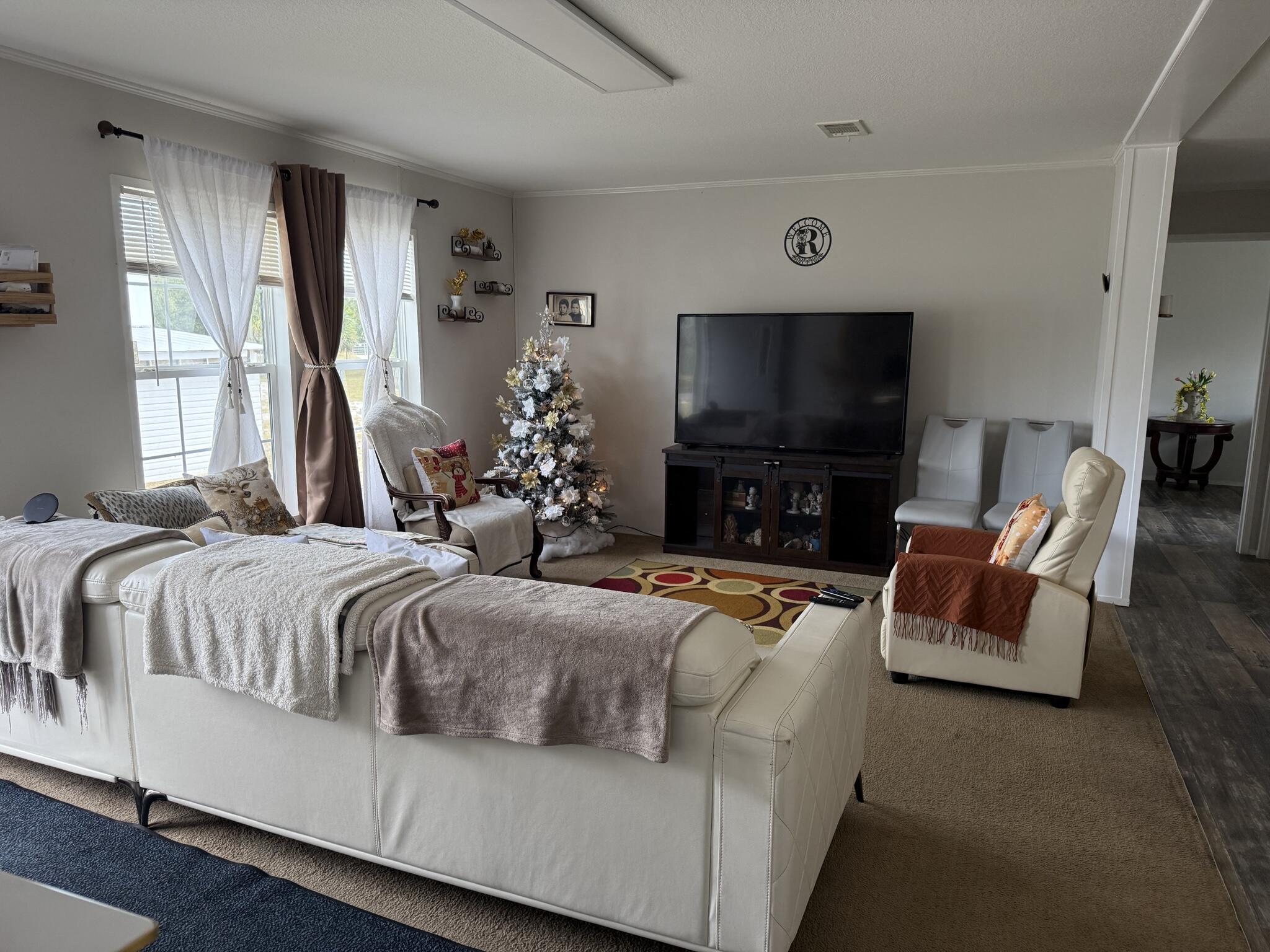 15628 Northwest 310th Street Okeechobee, FL 34972 - Photo 2 of 38 a spacious bedroom with a bed and a flat screen tv