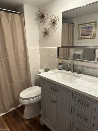 a bathroom with a granite countertop sink toilet and a mirror