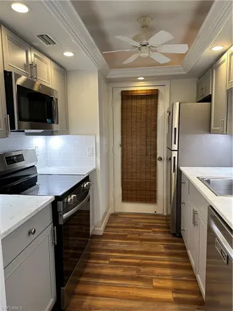 a kitchen with stainless steel appliances a stove microwave and refrigerator
