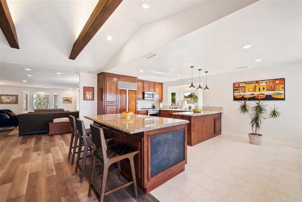 16416 Wikiup Road Ramona, CA 92065 - Photo 6 of 26 a kitchen with stainless steel appliances kitchen island granite countertop a table chairs sink and wooden floor
