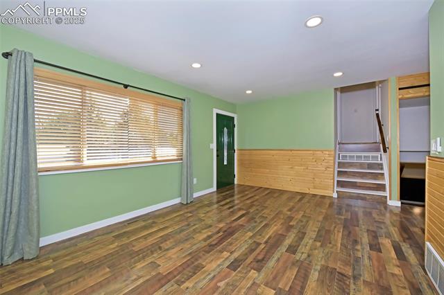 Spare room with wood finished floors, recessed lighting, and stairs