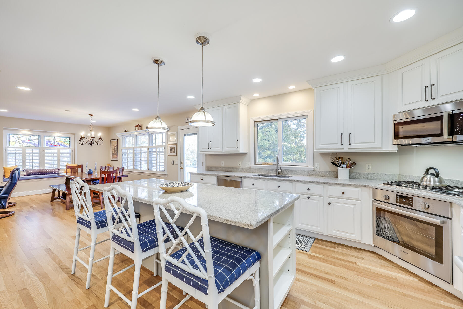 9 Ridgewood Road Orleans, MA 02653 - Photo 28 of 81 a open dining room with stainless steel appliances granite countertop a stove a sink a oven a dining table with chairs and white cabinets