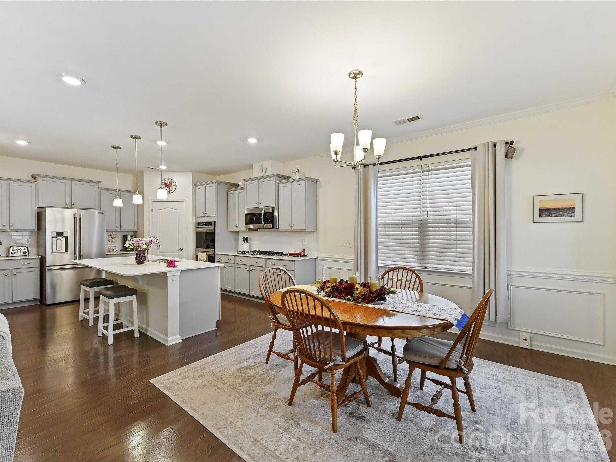 3302 Oliver Stanley Trail Lancaster, SC 29720 - Photo 12 of 48 a dining room with wooden floor a chandelier a wooden table and chairs