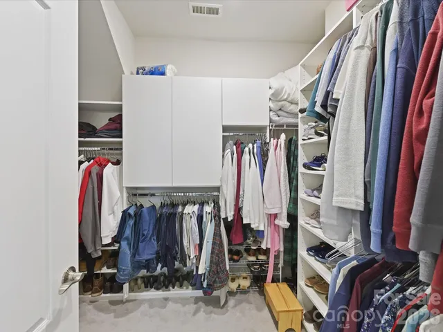 a view of walk in closet with clothes