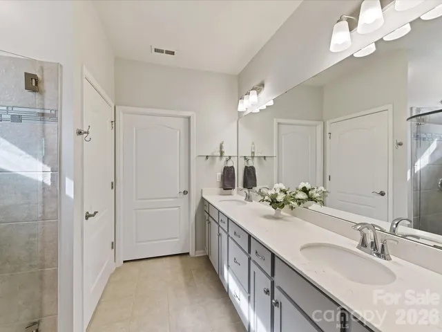 a bathroom with a double vanity sink mirror and shower