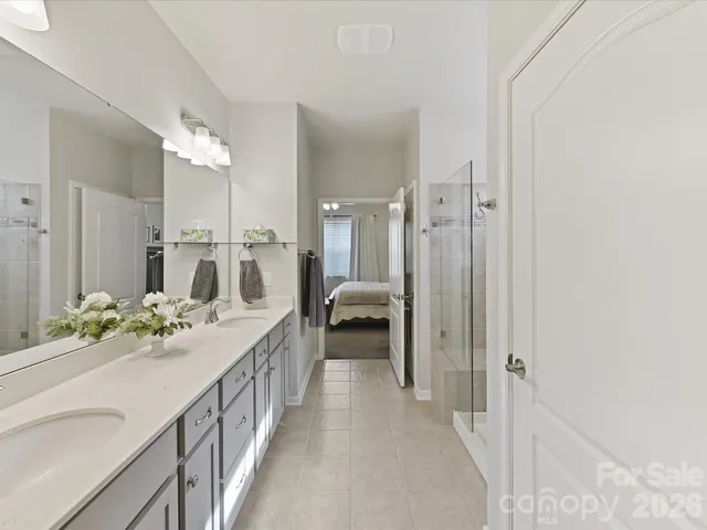 a en suite bathroom with a double vanity sink and a mirror
