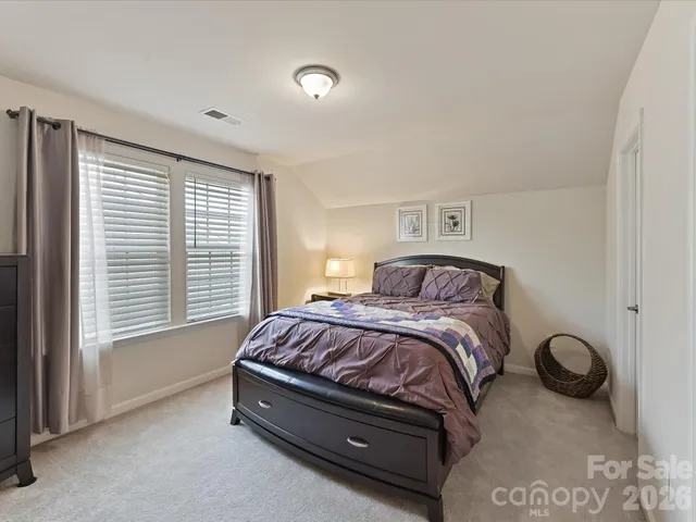 a spacious bedroom with a bed and a window