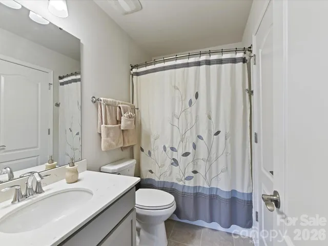 a bathroom with a shower curtain sink and a toilet