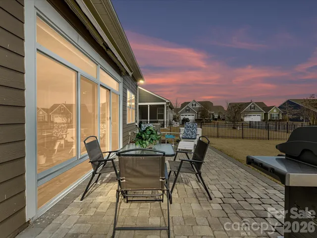 a roof deck with table and chairs and potted plants