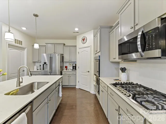 a kitchen with stainless steel appliances a sink a stove and a refrigerator