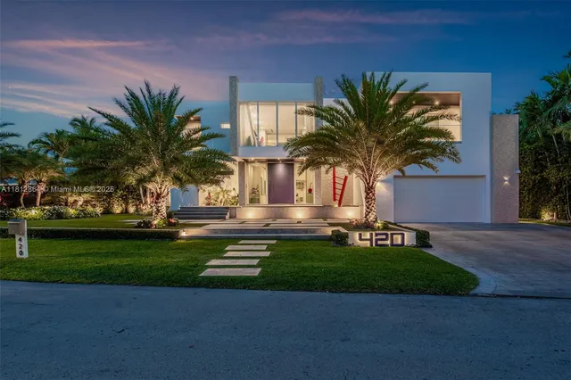 a view of a house with a yard and palm trees