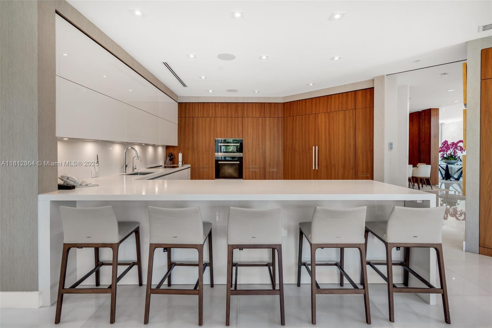 420 Island Drive Key Biscayne, FL 33149 - Photo 25 of 84 a kitchen with stainless steel appliances kitchen island granite countertop a table chairs sink and cabinets