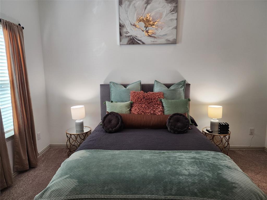 4704 Haltom Road Haltom City, TX 76117 - Photo 12 of 28 a bedroom with a bed and a chandelier