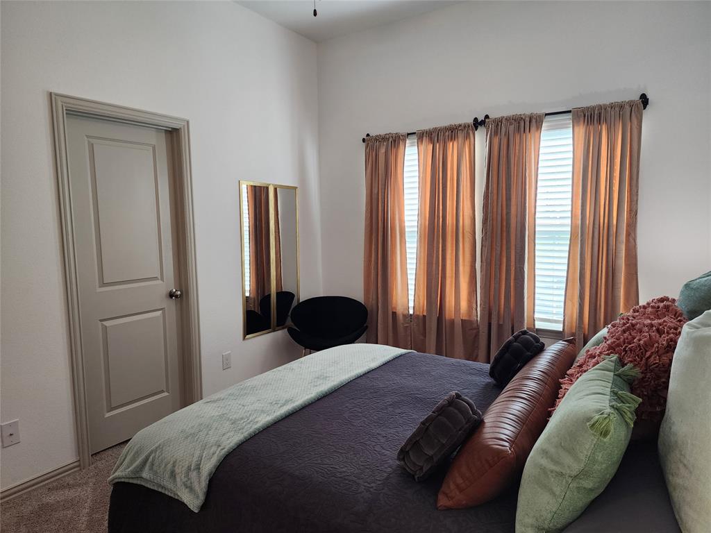 4704 Haltom Road Haltom City, TX 76117 - Photo 13 of 28 a bedroom with a bed and large windows