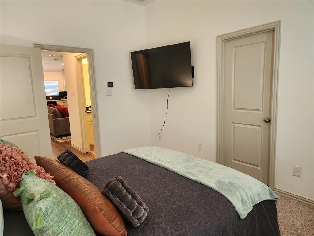 4704 Haltom Road Haltom City, TX 76117 - Photo 14 of 28 a bedroom with a bed and a flat screen tv