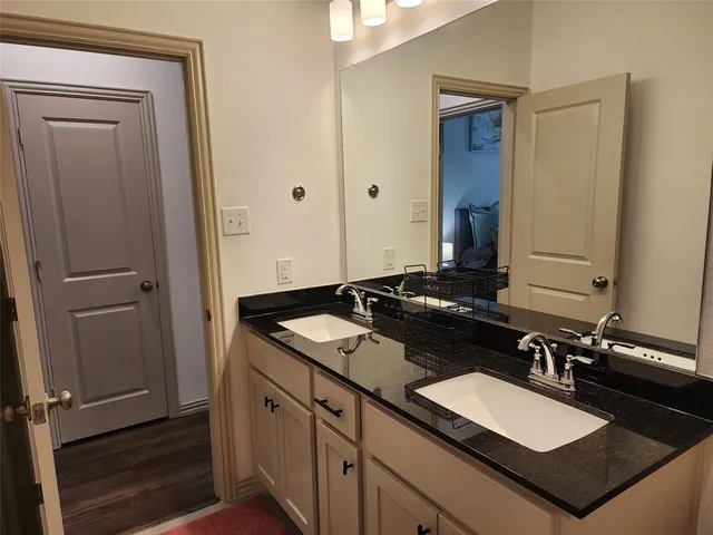 a bathroom with a granite countertop sink and a mirror