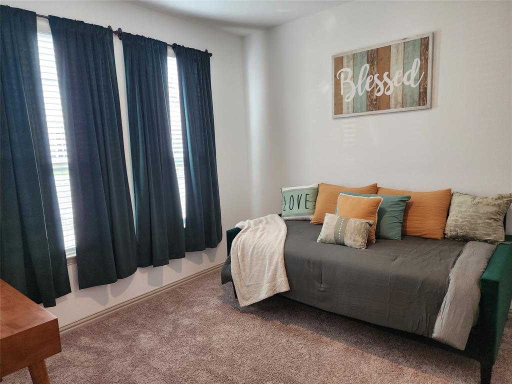 4704 Haltom Road Haltom City, TX 76117 - Photo 19 of 28 a bedroom with a bed lamp and a window