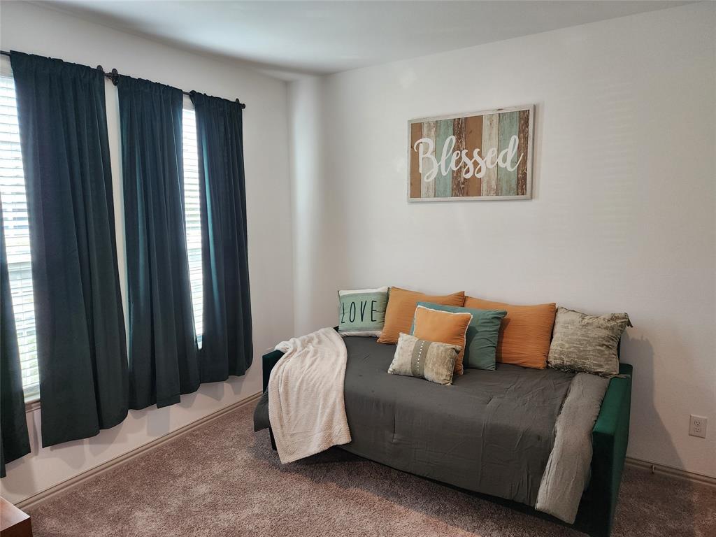 4704 Haltom Road Haltom City, TX 76117 - Photo 22 of 28 a bedroom with a bed and a painting on the wall