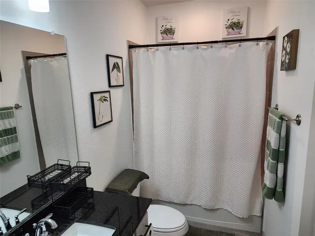 a bedroom with a bed and a painting on the wall