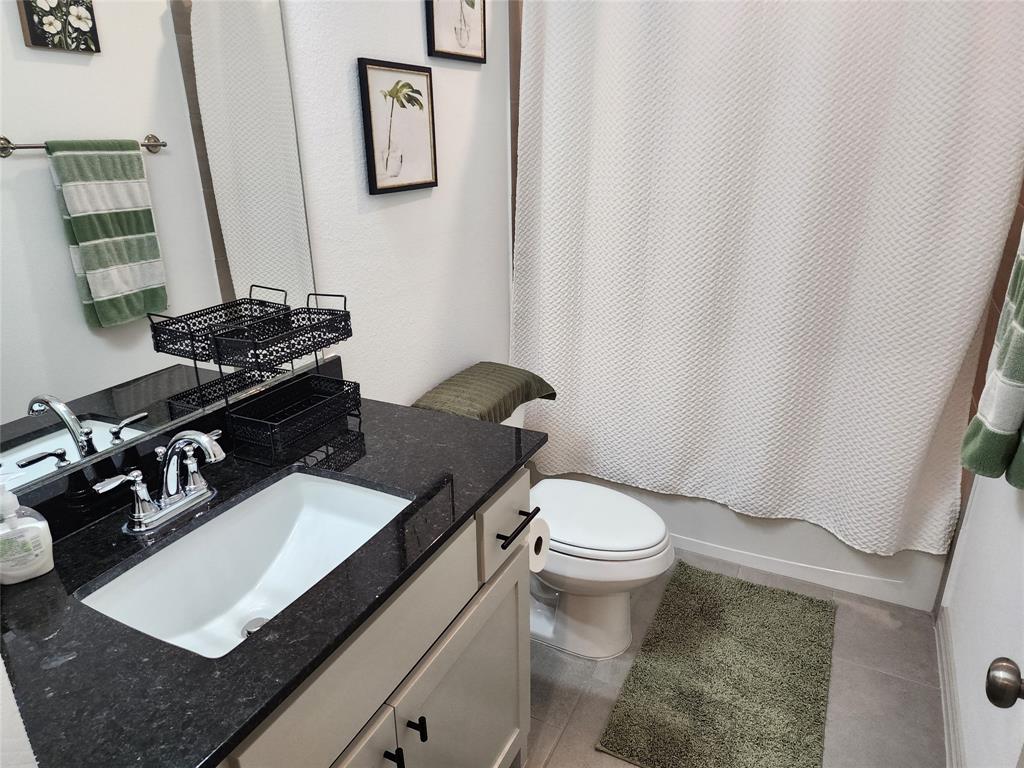 4704 Haltom Road Haltom City, TX 76117 - Photo 24 of 28 a bathroom with a granite countertop sink toilet and a mirror