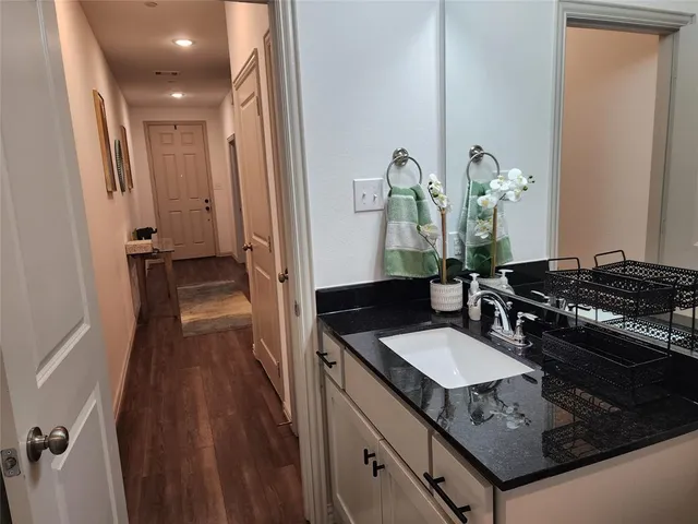 a bathroom with a granite countertop sink toilet and a mirror